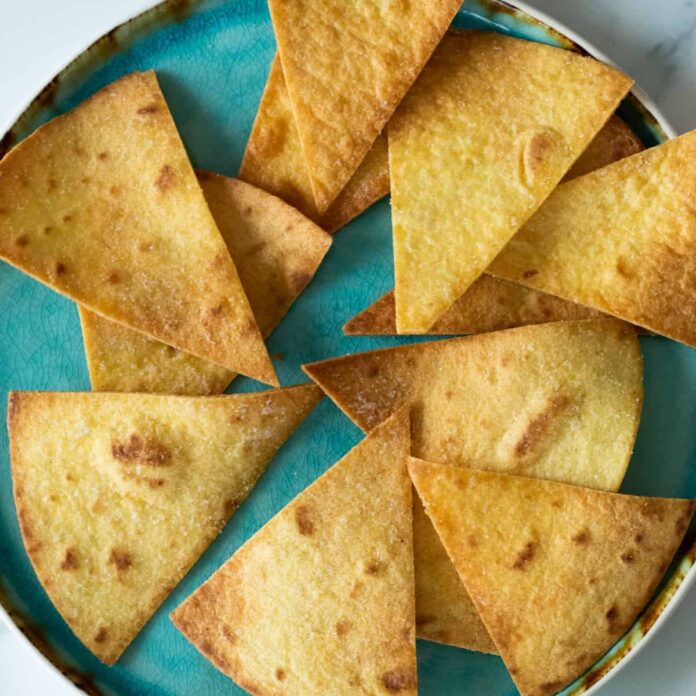 homemade tortilla chips on a blue plate