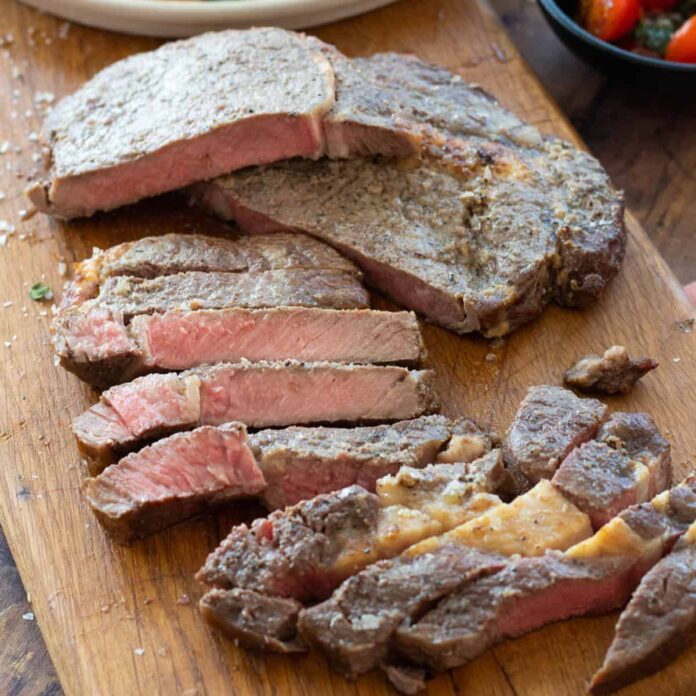 sliced steak on a wooden chopping board