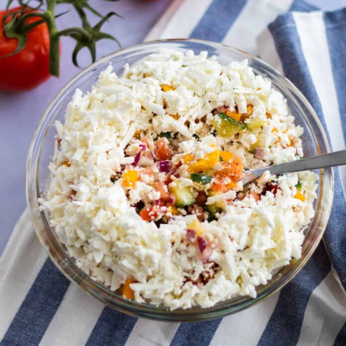 shopska salad topped with feta cheese