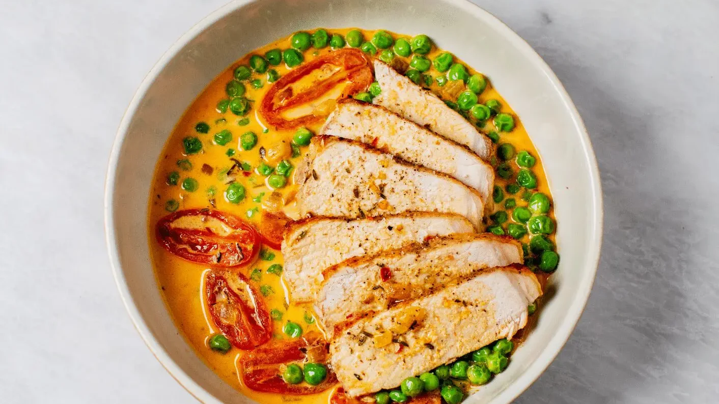 Côtelettes de porc avec pois et tomates crémeux
