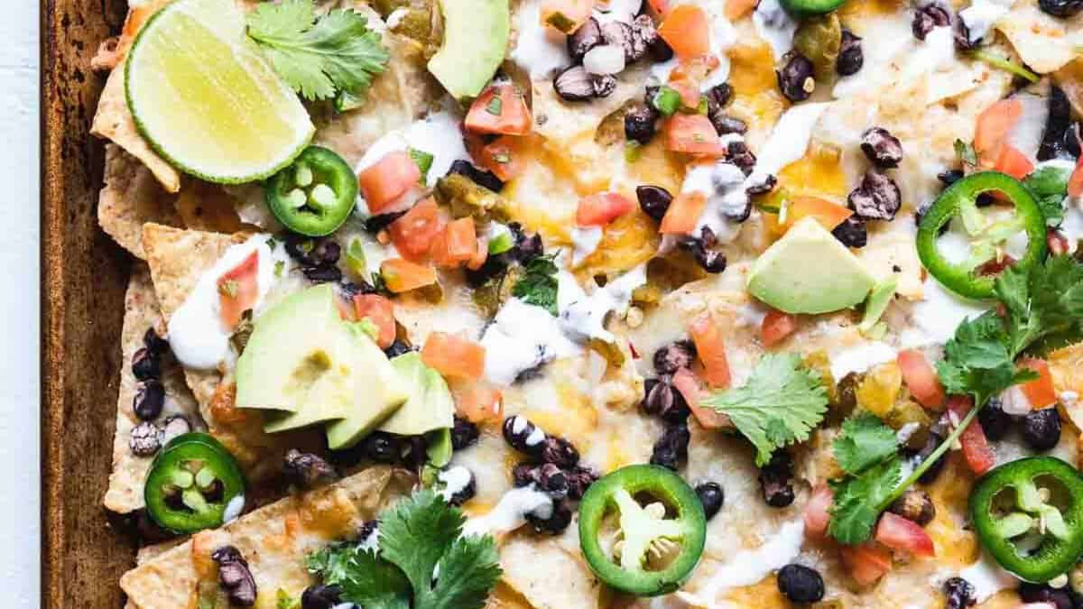 Nachos cuits au four avec fromage et quartiers de citron vert.