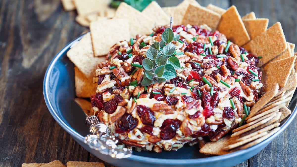 Une boule de fromage avec des canneberges et des noix.
