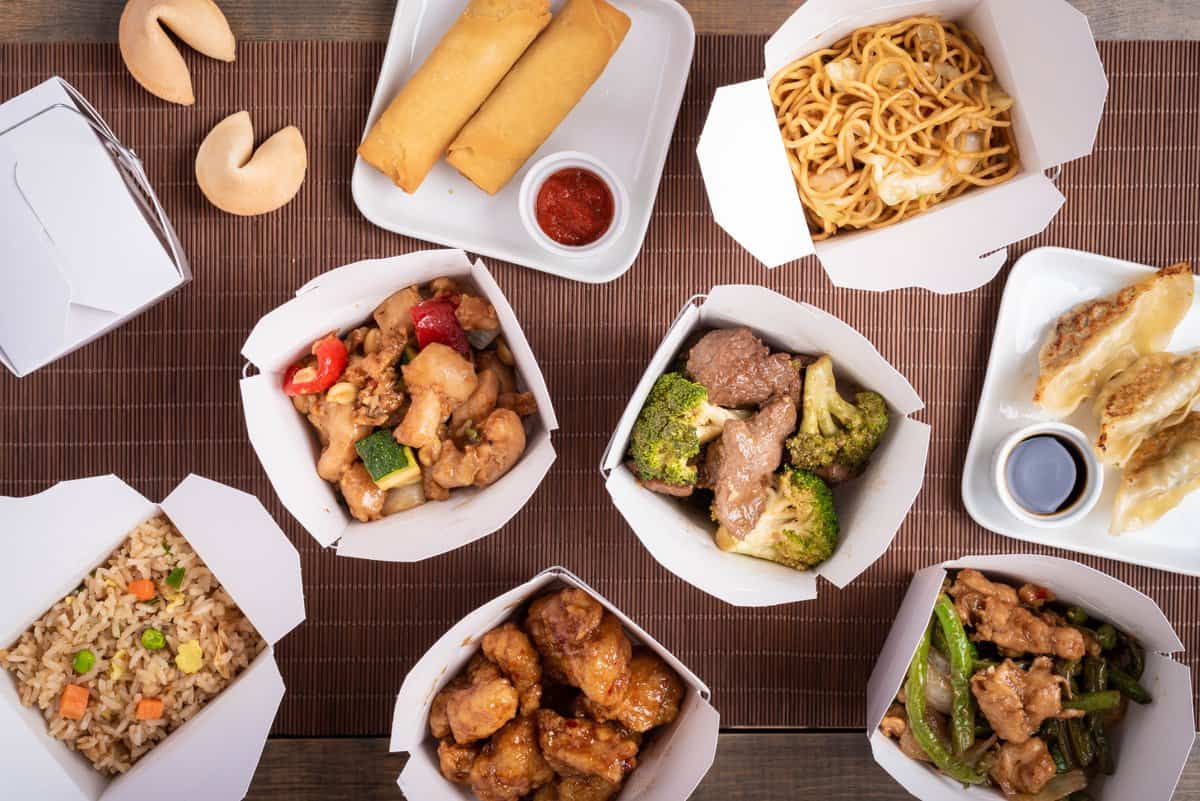 Un assortiment de plats chinois américains dans des boîtes à emporter.