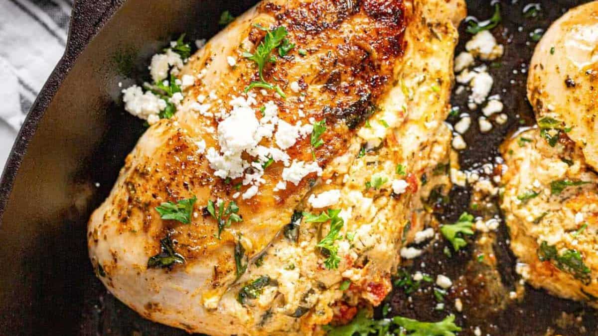 Poitrine de poulet farcie dans une poêle noire.