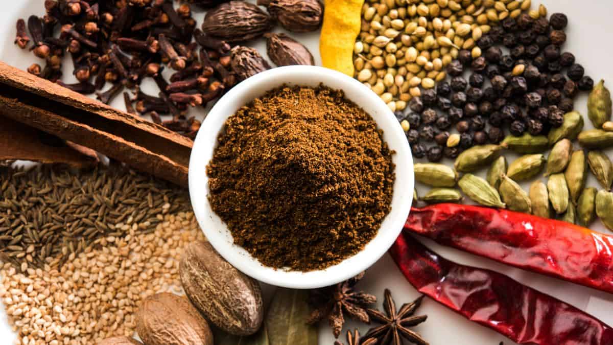 Un bol de garam masala entouré des épices nécessaires pour le préparer.