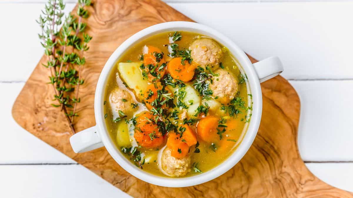 Un bol de soupe avec des légumes et des boulettes de viande.
