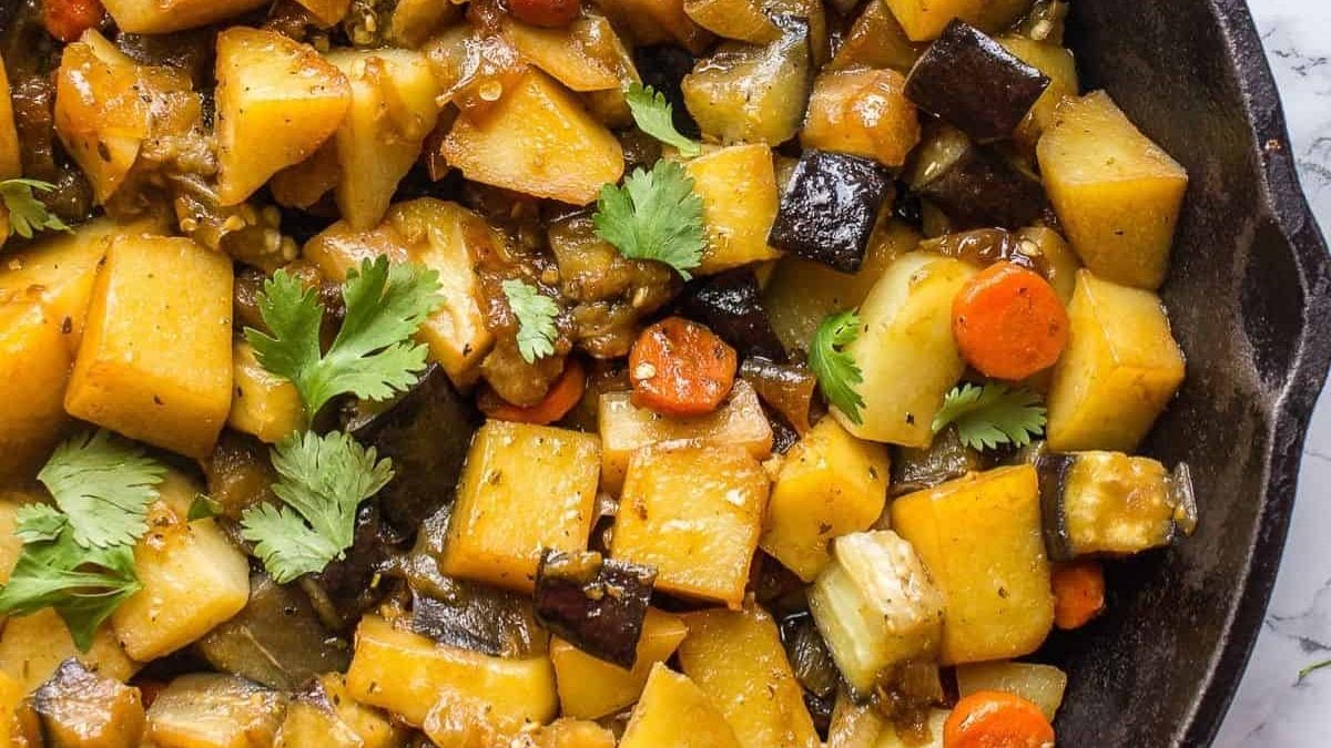 Une poêle pleine de ragoût d'aubergines et de pommes de terre.