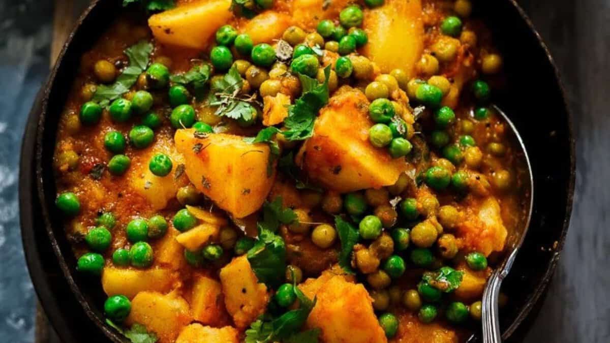 Recette Aloo Matar à l'Autocuiseur sans Oignon-Ail dans un bol noir.
