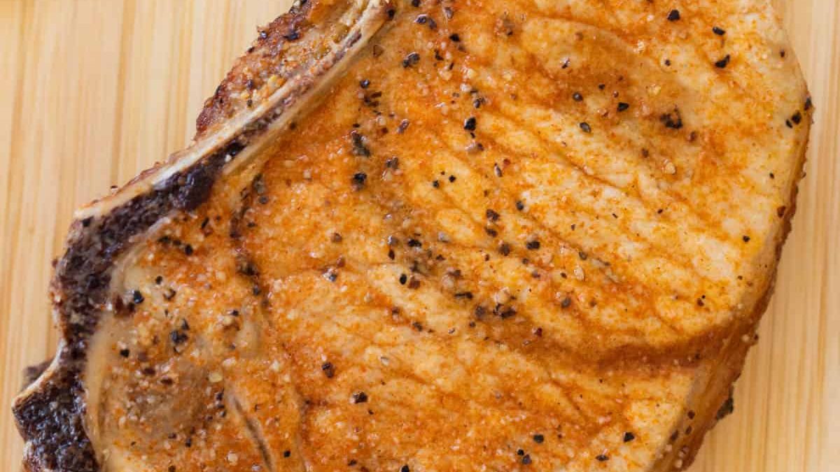 Une côtelette de porc sur une petite planche à découper.