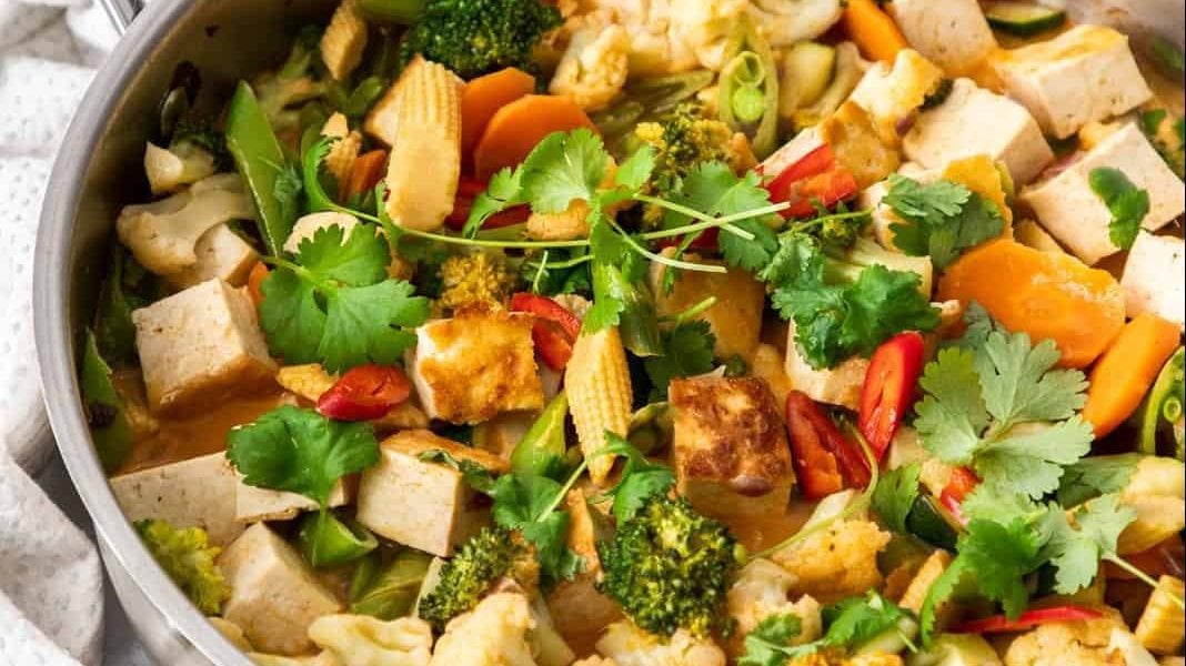 Sauté de tofu au curry rouge dans une poêle.