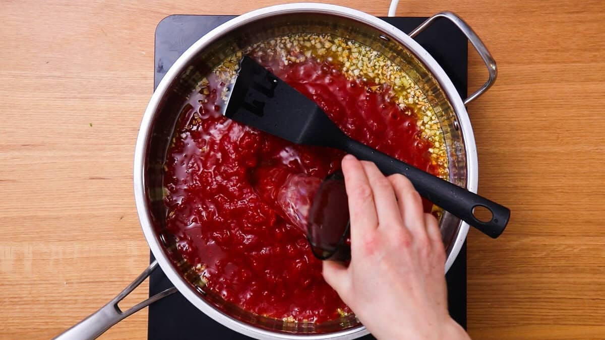 Ajout de vin blanc pour réaliser une sauce tomate facile.