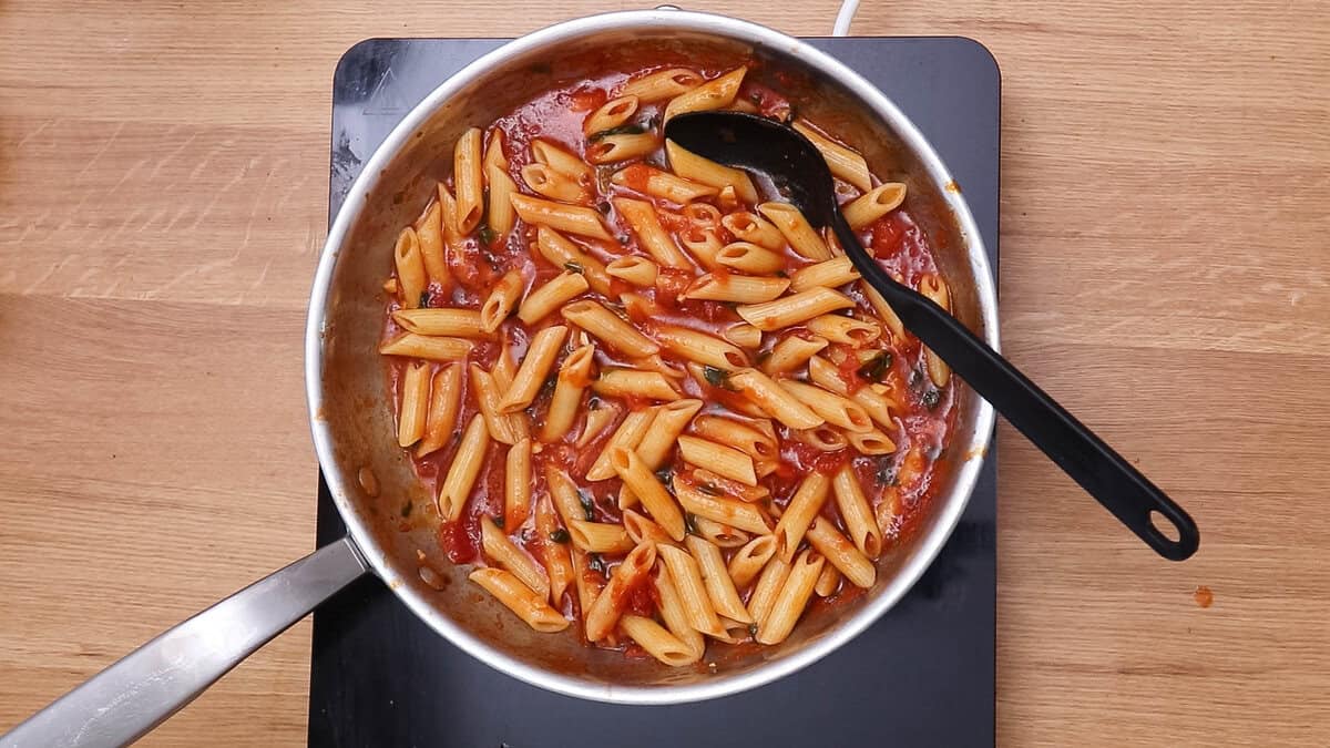 Penne pomodoro ou pâtes avec sauce tomate basilic dans une poêle après cuisson.