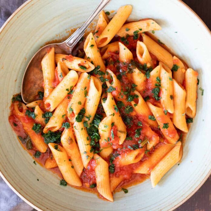 A bowl with penne pomodoro (pasta with basil tomato sauce).