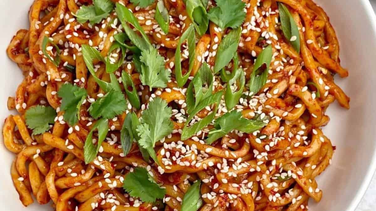 Nouilles à l'huile de chili avec graines de sésame et oignons verts hachés.