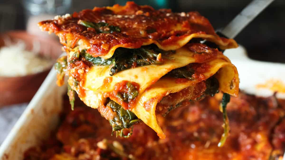 Lasagne aux épinards avec sauce tomate, tomates séchées et pignons.