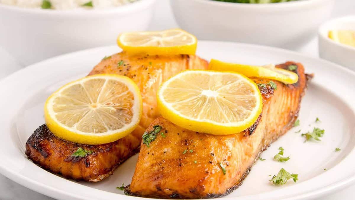 Deux tranches de saumon avec des tranches de citron sur une assiette.