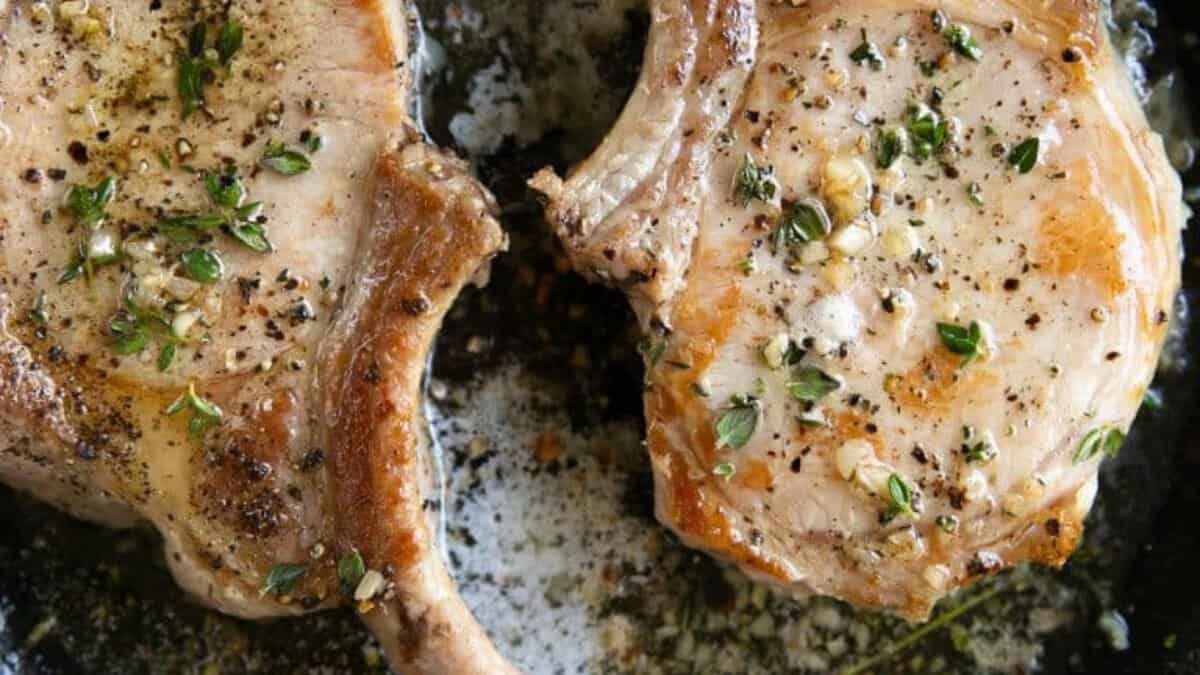 Deux côtelettes de porc dans une poêle.